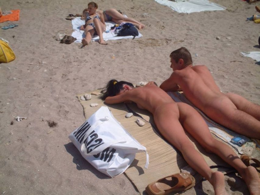 Несколько блядей загорают голышом на нудистском пляже и играют с парнями мячом